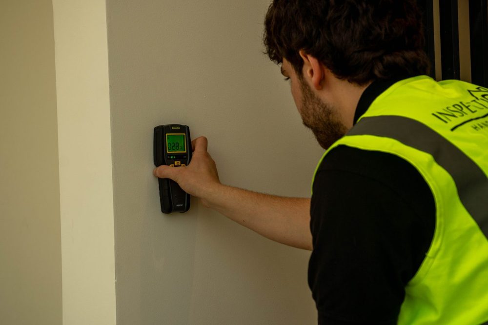 An Inspecto Handover inspector taking a moisture reading